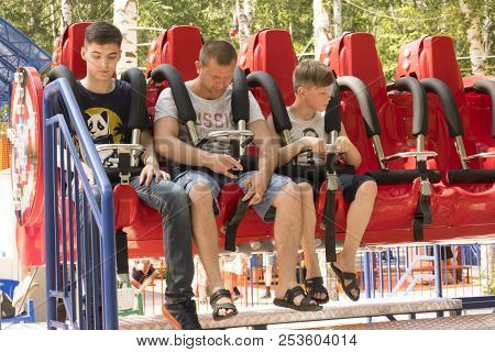 People Are Sitting On An Attraction In Gagarin Park, July 1, 2018, Russia, The City Of Sterlitamak