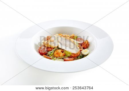 Caesar Salad with a Crispy Chicken Isolated on White Background. Restaurant Main Course with Turkey Fillet, Quail Eggs, Mini Baguette Rusks, Cherry Tomatoes, Lettuce Leaves, Sauce and Parmesan Cheese