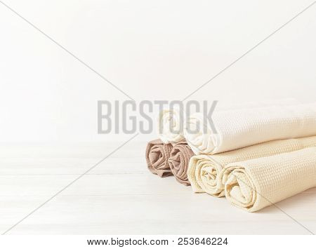 Multicolored Clean Towels On A Light Wooden Background With Copy Space. Texture Of Cotton, Waffle To