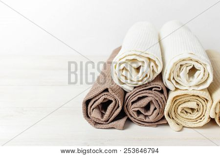 Multicolored Clean Towels On A Light Wooden Background With Copy Space. Texture Of Cotton, Waffle To