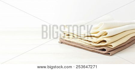 Multicolored Clean Towels On A Light Wooden Background With Copy Space. Texture Of Cotton, Waffle To