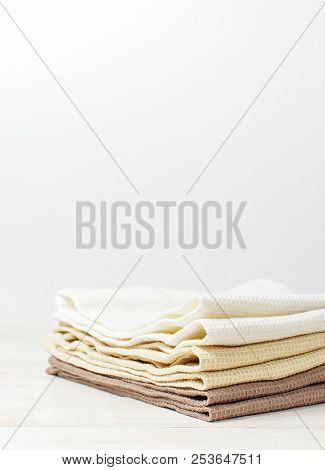 Multicolored Clean Towels On A Light Wooden Background With Copy Space. Texture Of Cotton, Waffle To