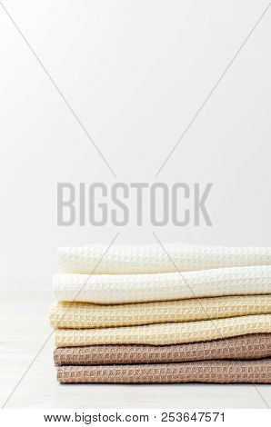 Multicolored Clean Towels On A Light Wooden Background With Copy Space. Texture Of Cotton, Waffle To