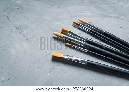 Painting Brusches On Gray Concrete Background. Flat Lay, Top View
