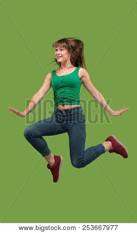 Freedom In Moving. Mid-air Shot Of Pretty Happy Young Woman Jumping And Gesturing Against Orange Stu