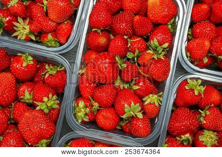 Close Up Of Fresh Red Ripe Strawberries In Transparent Plastic Container Boxes On Retail Market Disp