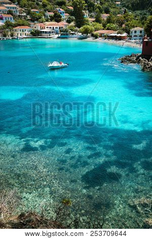 Assos Village, Kefalonia Greece. Transparent Turquoise Emerald Green Sea Water With Dark Pattern On 