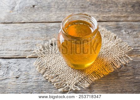 Glass Jar Of Honey, Linden Flowers On Wooden Background.