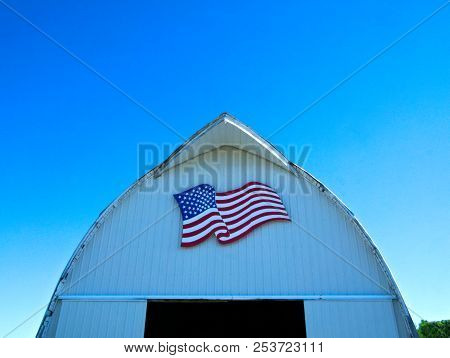 Front Of White Barn With American Flag On Minnesota Farm With Blue Sky