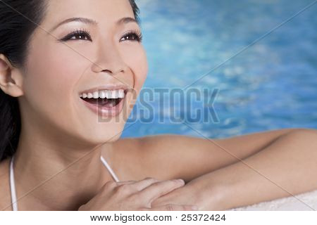 Een mooie sexy jonge Chinese Aziatische Oriental vrouw dragen van een bikini en ontspannen aan de zijkant van een s
