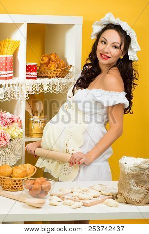 A Professional Pregnant Chef In The Kitchen Prepares The Dough With Flour To Make The Baking