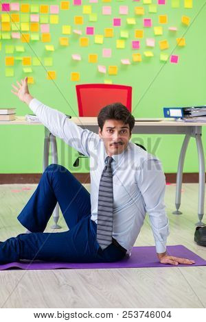 Man in the office with many conflicting priorities doing exercis