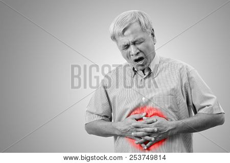 Older Asian Man Is Having Stomach Ache Pain Concept With Isolated Background. Senior Or Mature Peopl