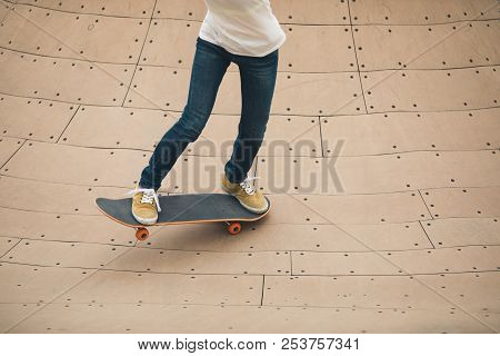 One Woman Skateboarder Sakteboarding On Skatepark Ramp