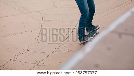 One Woman Skateboarder Sakteboarding On Skatepark Ramp