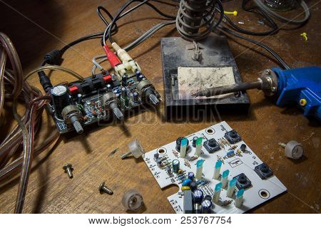 Circuits, Soldering Iron And Volume Knob On Wood Table.