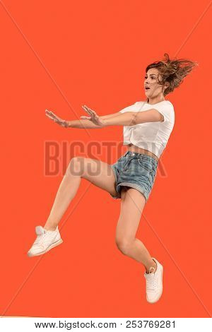 Freedom In Moving. Mid-air Shot Of Pretty Happy Young Woman Jumping And Gesturing Reject Against Ora
