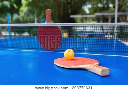 Pingpong Rackets And Ball And Net On A Blue Pingpong Table