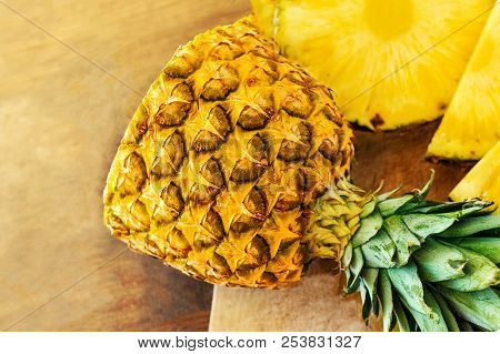 Pineapple On Wood Texture Background. Whole And Sliced Tropical Pineapple On Wooden Cutting Board  W