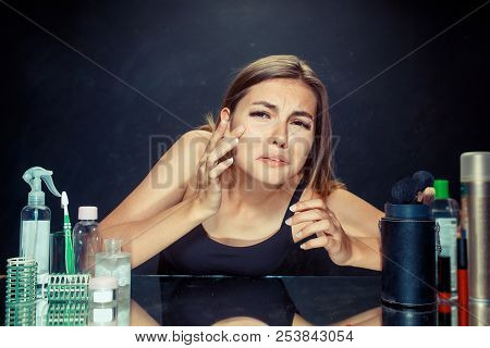 Unsatisfied Unhappy Young Woman Looking At Her Self In Mirror On Black Studio Background. Roblem Ski