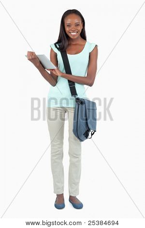 Leende ung student med hennes scratchpad mot vit bakgrund