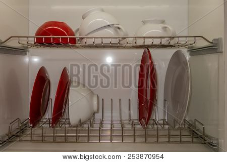 White Porcelain Dishes Dried On Metal Dish Rack. Way To Organize Kitchen And Minimize Space With Mod