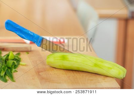 Healthy Eating, Dieting, Preparing Fresh Vegetables Salad. Green Peeled Cucamber With Knife On Woode