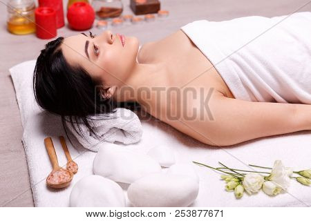 A Fragrant Massage On The Floor.young Woman Enjoying Massage In Spa Salon