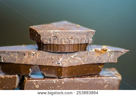 Dark Chocolate Bars Stacked Up With Dark Background In The Ktichen