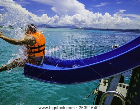 Asian Man Playing The Slider On The Boat With Amzing Idyllic Ocean And Blue In Vacation Time.summer 