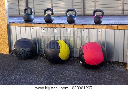 Iron Dumbbells Of Different Weights With Multi-colored Handles Stand In The Gym On A Rubber Mat. Med