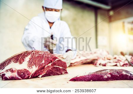 Butcher Cutting Raw Meat Beef In Slaughterhouse.
