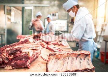 Butcher Group And Friends Works In A Slaughterhouse And Cuts Raw Beef
