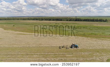 Aerial, View Agricultural Machinery With Wheeled Rake Makes Ranks Beveled Hay.tractor Which Is Linin