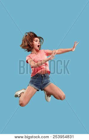 Freedom In Moving. Mid-air Shot Of Pretty Happy Young Woman Jumping And Gesturing Reject Against Blu