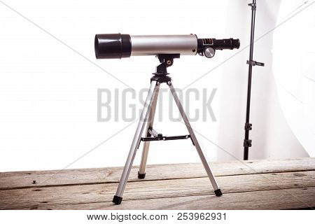 Telescope On A White Background Laid On Wooden Board