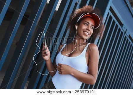 Young Woman In Tennis Visor And Earphones Free Style On The Stre