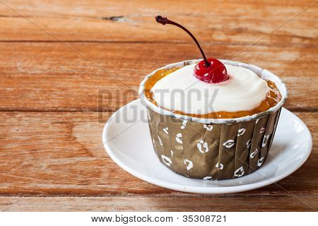 Orange Marmalade Cupcakes decorated with red cherry
