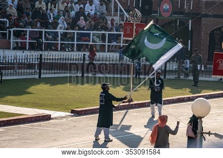 Wagah, Pakistan - Febuary 8, 2020: Two Pakistani Men Wave Flags And Hype Up The Crowd For The Wagah 