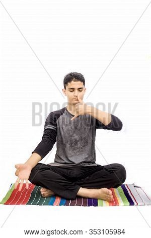 Full Body Shot Of Male Teenager Doing Nadi Shdhana Pranayama Or Alternate Nostril Breathing Isolated