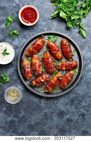 Bacon Wrapped Grilled Chicken Wings On Plate Over Blue Stone Background. Tasty Snack From Chicken Me