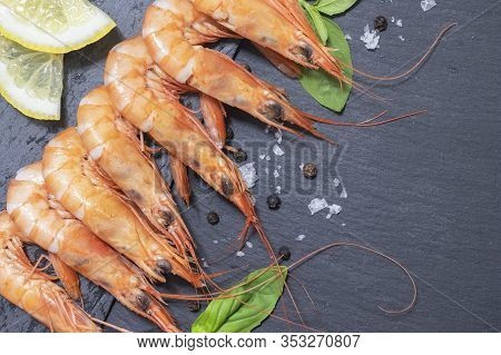 Red Bolied Prawns On Black Background With Lemon And Basil