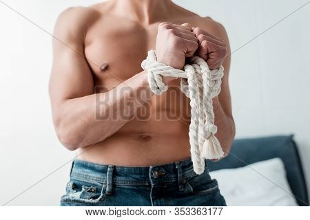 Cropped View Of Submissive And Shirtless Man Tied With Rope