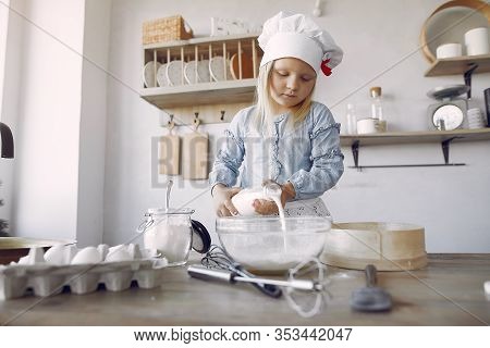 Little Girl In A White Shef Hat Cook The Dough For Cookies