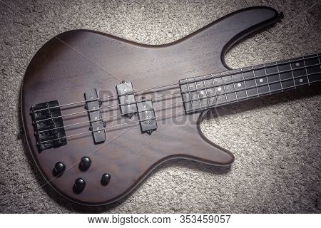 Bass Guitar With Four Strings. Popular Rock Musical Instrument. Top View Of Brown Electric Bass On C