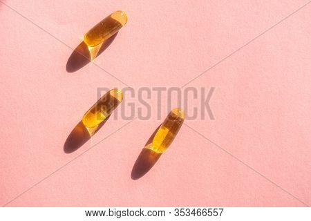 Oil Yellow Gelatin Capsules On Pink Background, Vitamins And Antioxidant Concept Omega 3, Liver Cod 