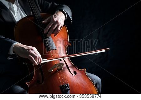 Cello player or cellist performing in an orchestra background isolated with copy space
