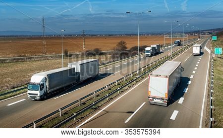 Convoys Of Transportation Trucks Passing On A Highway On A Bright Blue Day. Highway Transportation W