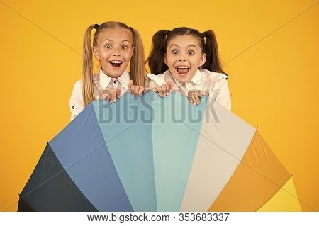 Umbrella Surprise. Surprised Girls Hiding Behind Umbrela On Yellow Background. Little Children Looki