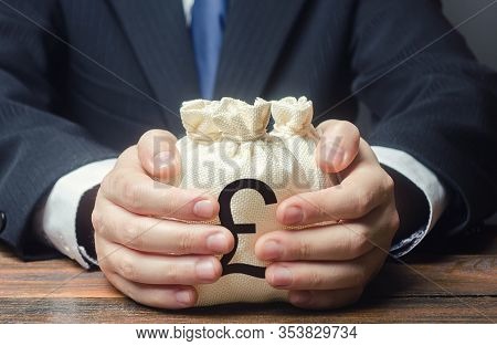 Businessman Hugs Pound Sterling Money Bags. Budget, Tax Collection. Granting Financing Business Proj